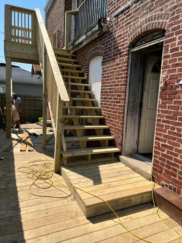 New wood exterior stairs against a brick building