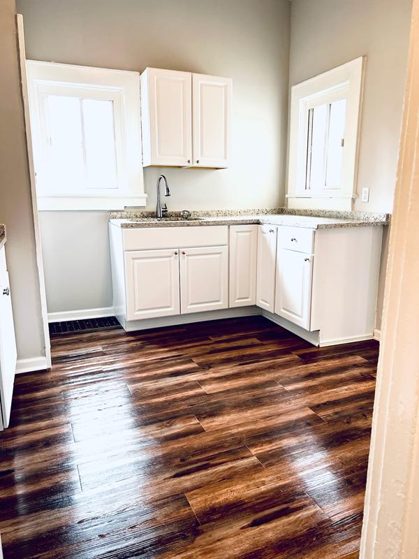 White kitchen with refinished dark hardwood floors