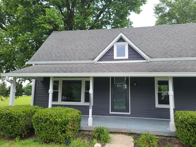 Finished blue-gray house with white trim, gutters and front porch