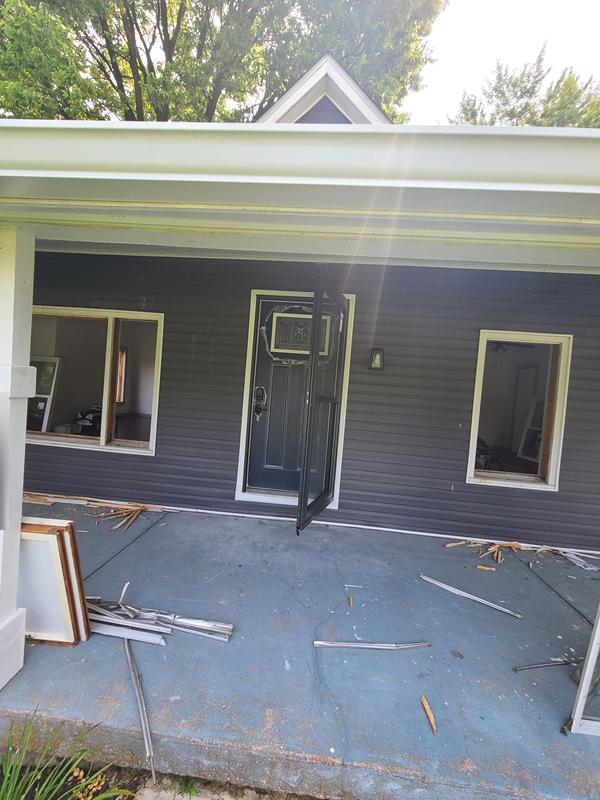 Front porch being rebuilt with new blue-gray siding going up