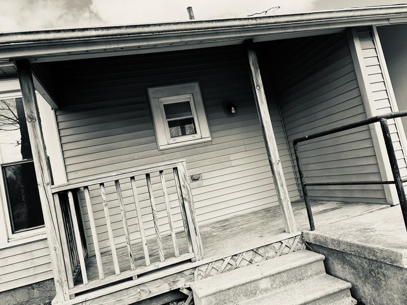 Worn front porch and siding before the rehab