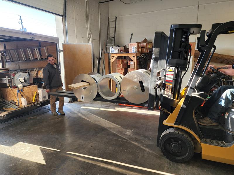 Inside the Perfect Start shop with gutter coil and a forklift