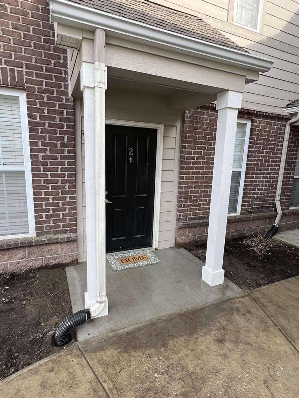 New concrete stoop with white columns at an apartment entry